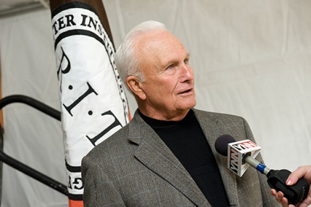 Professor speaking in front of University flag