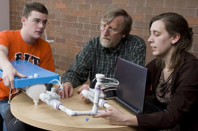 People gathered around table looking at project