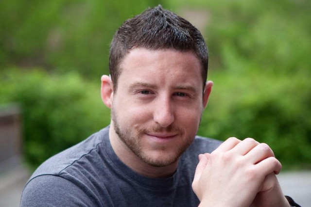 head-and-shoulders view of recent graduate wearing gray T-shirt