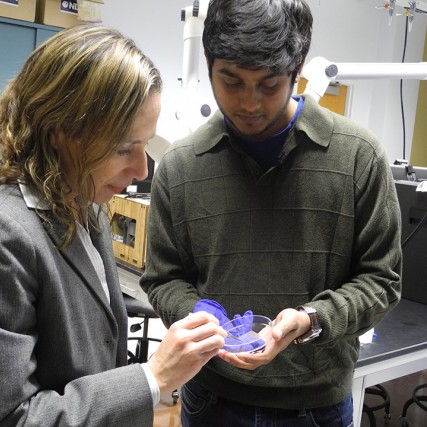 Faculty member and student hold petri dish