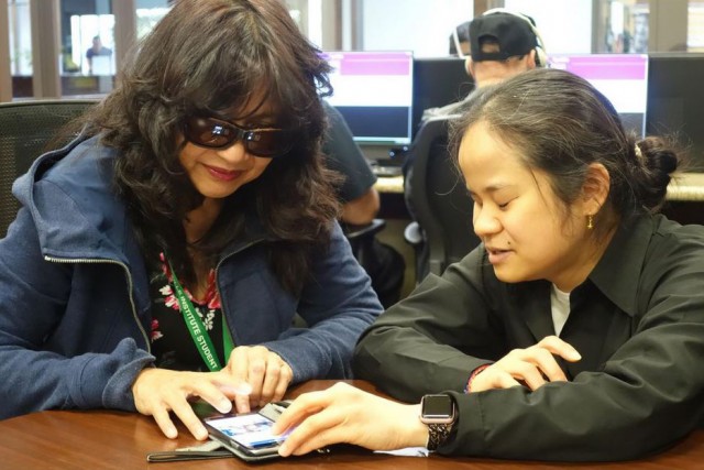 Two people look at smartphone.