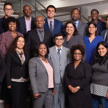 Group of people stands in three rows on stairwell.