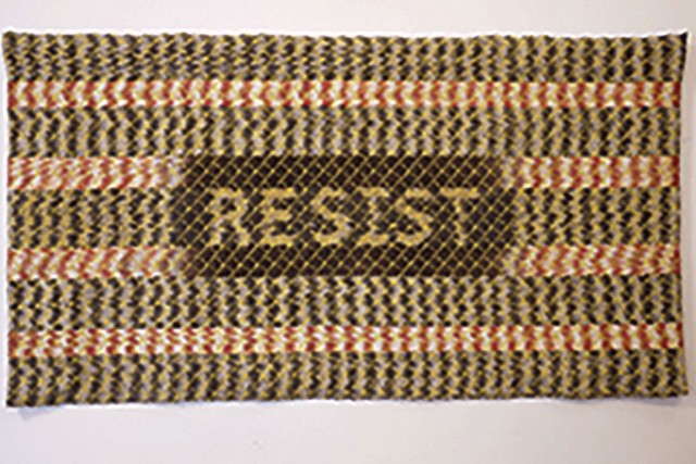 Knit rug with the word "RESIST" in the center.