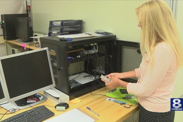 Scientist holds vape-measuring device.