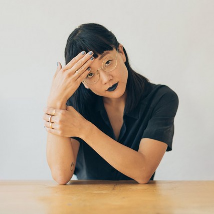Christine Sun Kim sitting at a table.