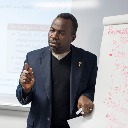 professor giving lecture using large presentation paper on easel.