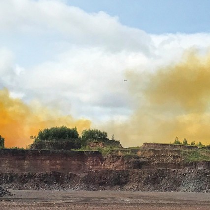 blast zone with yellow-orange gas in the background.