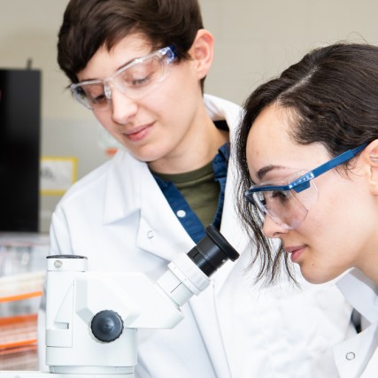 student looking into a microscope