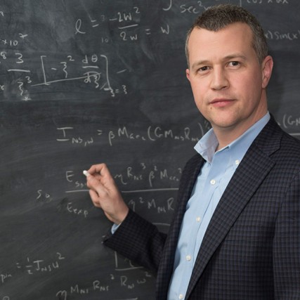 professor writing on chalkboard.