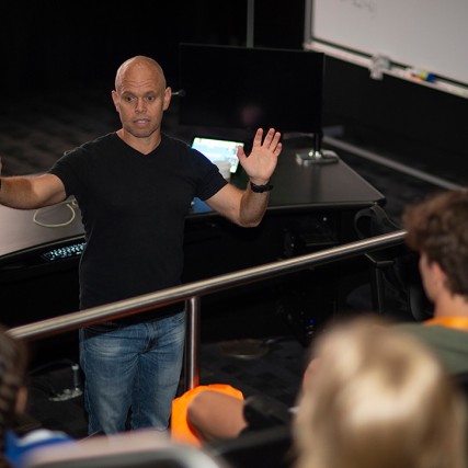 professor speaking to students in a studio.