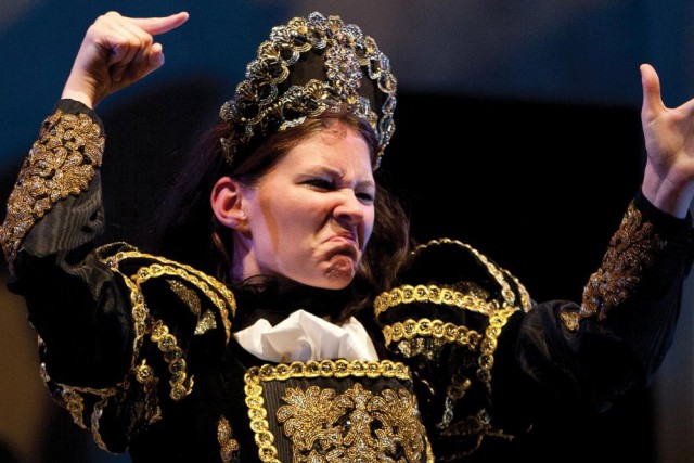 woman dressed in period clothing performing a scene from Hamlet in American Sign Language.