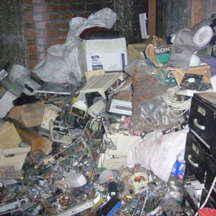mounds of electronic garbage piled up in a room.