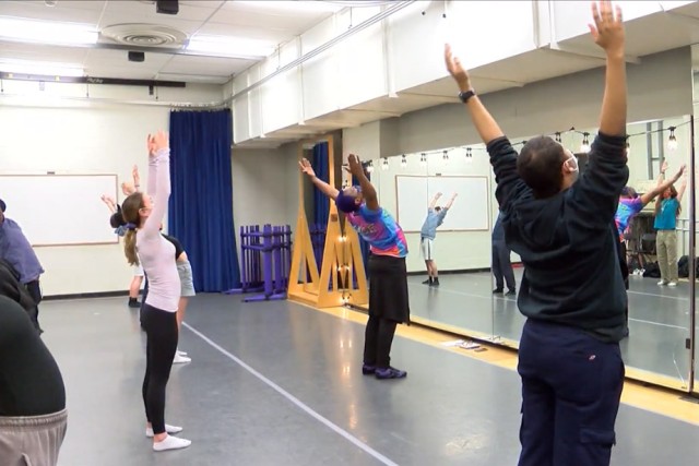 instructor and students in a dance studio.