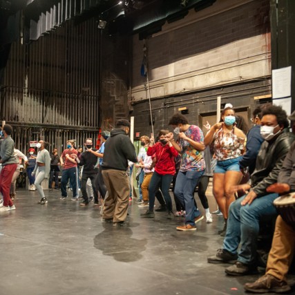 performers on stage rehearsing In the Heights.
