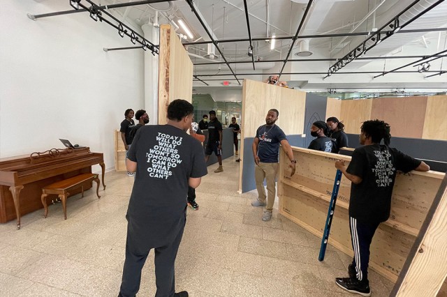 volunteers framing out walls for an art exhibition.