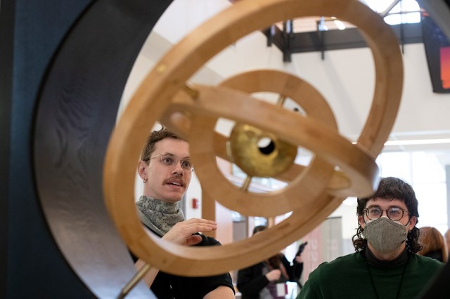two people looking at a sculpture with three concentric circles.