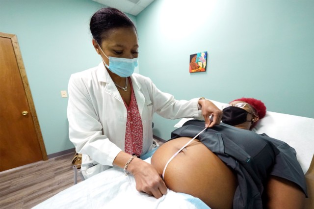 doctor measuring a pregnant woman's belly.