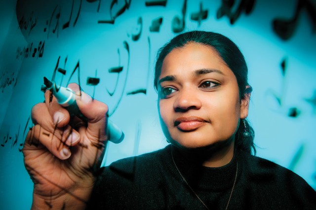 researcher writes on a clear surface with a marker.