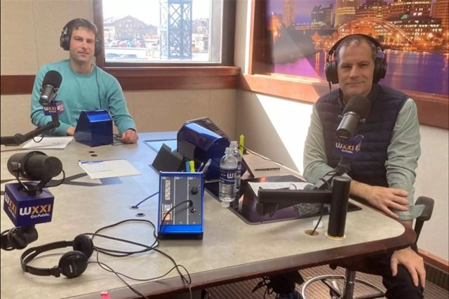 two people sitting in a radio station room.