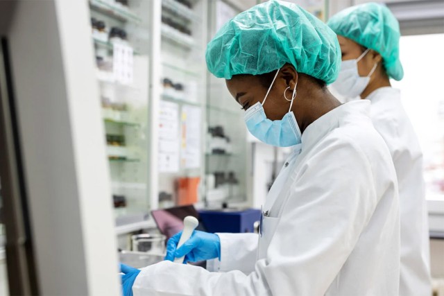 scientist wearing a lab coat and hair net.