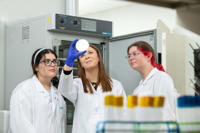 Assistant Professor Elle Barnes is shown working in the state-of-the-art genomics lab with students Emma Thompson and Hannah Zarum