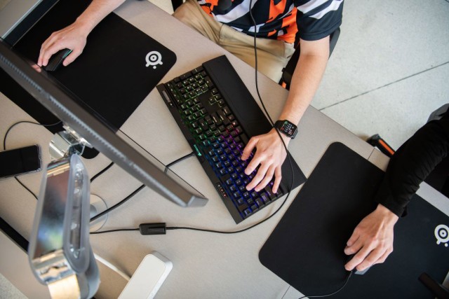 a view from above a computer workstation shows two students working on computers and keyboard