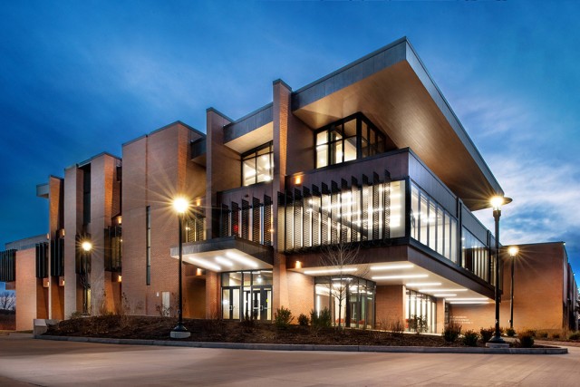 a photo of the Saunders College of Business building is shown in the evening.