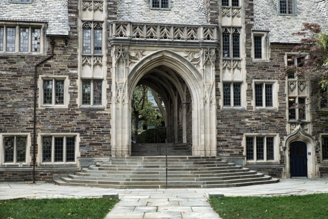 Stone building on college campus, with steps and archway.