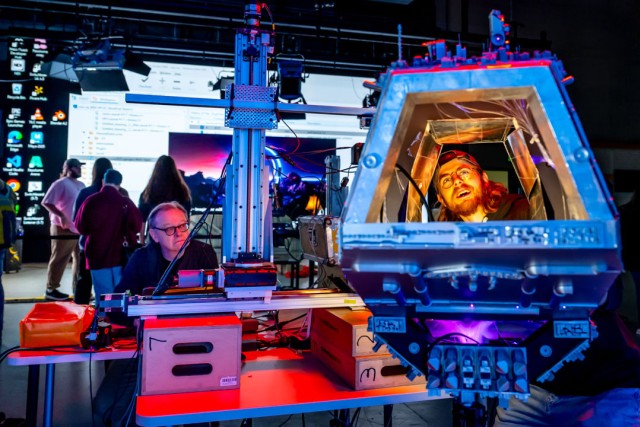 A student appears inside his robot spaceship at the Virtual Production Experience exhibit at Imagine RIT.