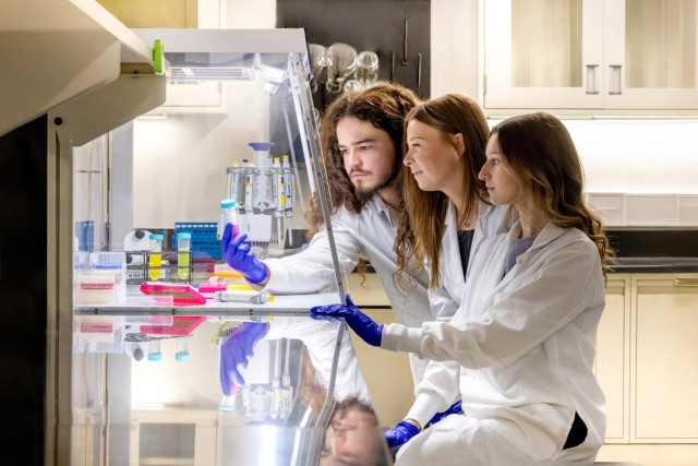 Assistant Professor Elle Barnes, center, works with students William Goyette, left, and Lilly Rennie, right, in the MEGA Lab on RIT’s campus. 
