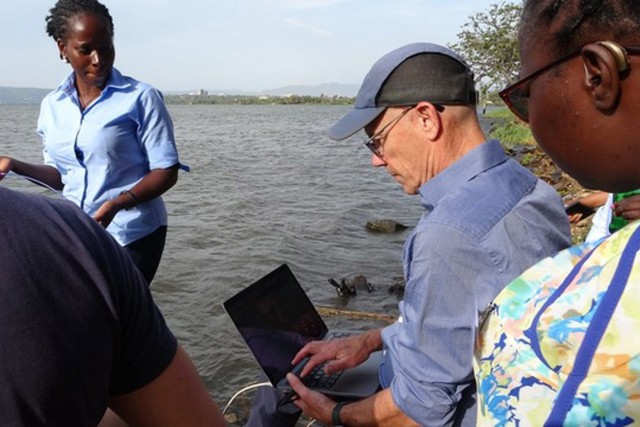 Professor Anthony Vodacek, center, consults with fellow researchers on a previous trip to Lake Victoria in Africa. He is returning to the continent as a Fulbright Scholar.
