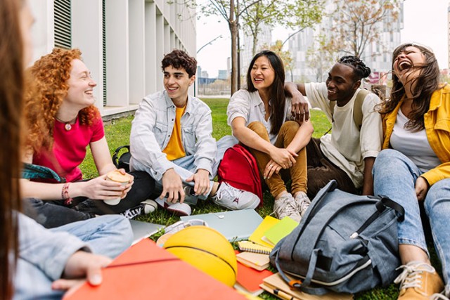 students sitting outside in a college setting.