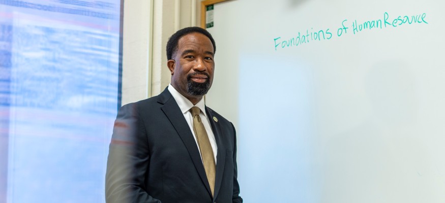 black man standing in front of white board