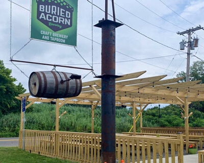 Buried Acorn Brewery sign outside of the building, with exterior seating area in background