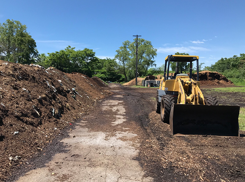 piles of compost with a tractor across it