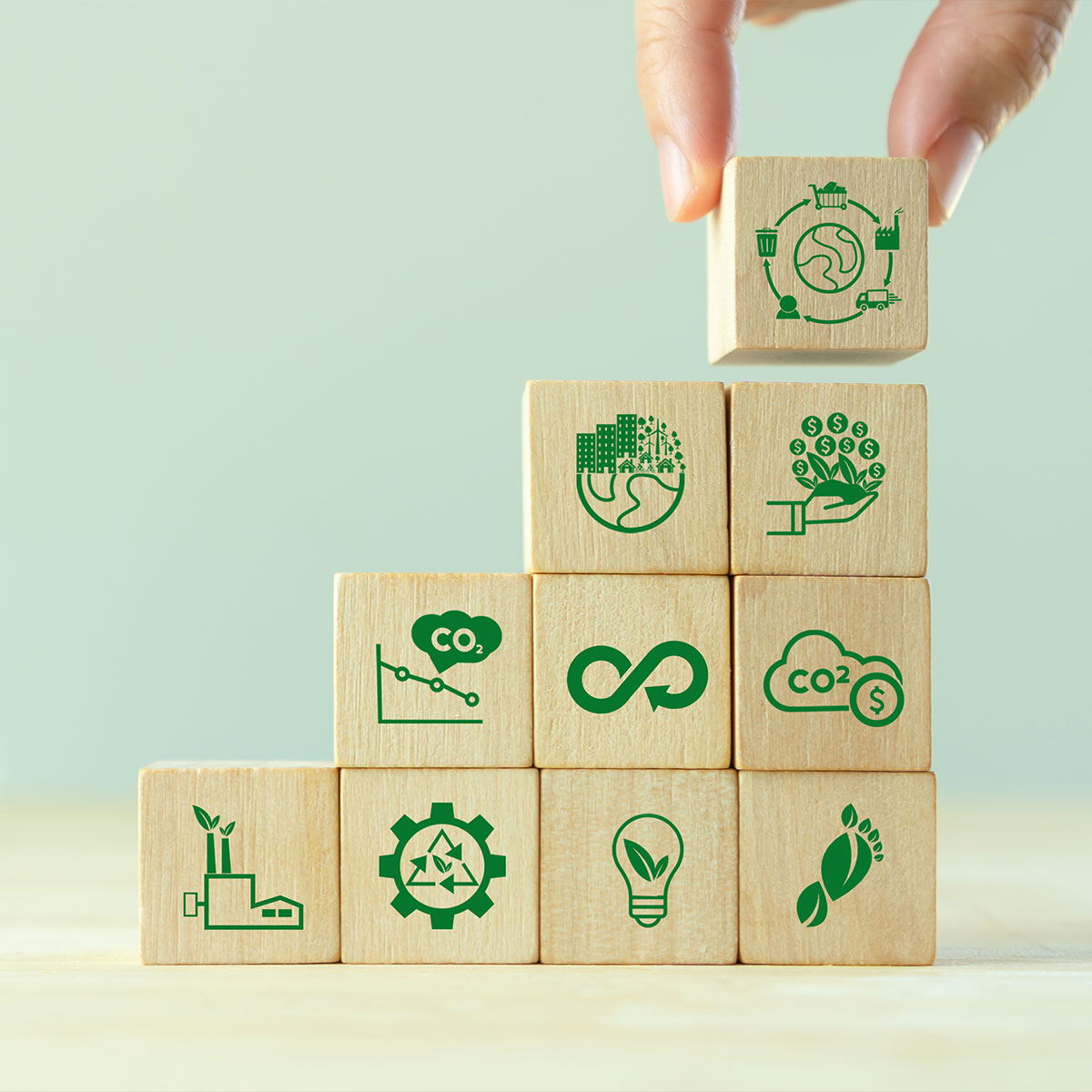 hand building a stack of blocks, each with an icon depicting Growing sustainability. LCA-Life cycle assessment concept. Assessing environmental impacts associated on value chain product. Carbon footprint evaluation. ISO LCA standard, aim to limit climate change
