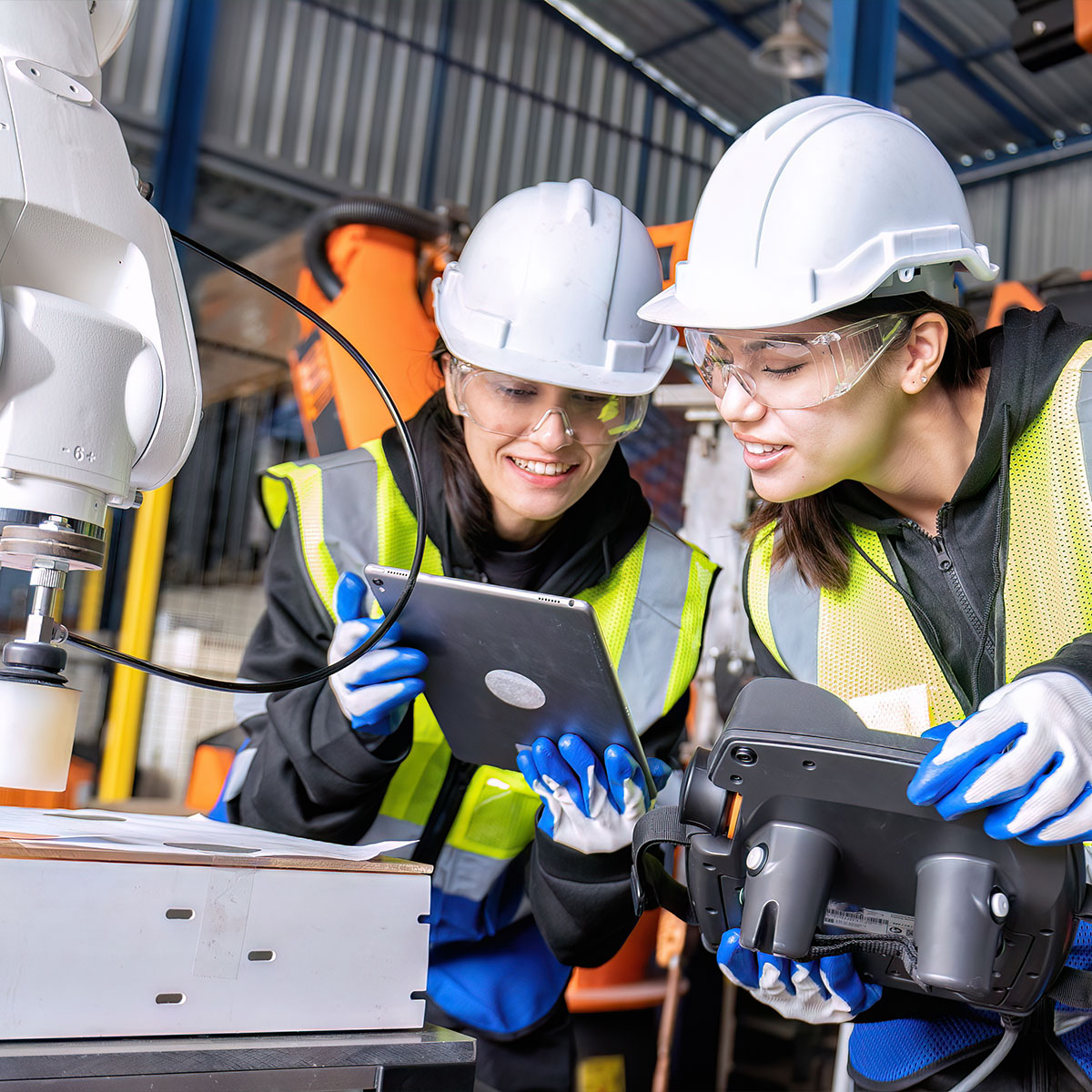 Women engineer team together at work in modern advanced robot welding machine sell service factory 