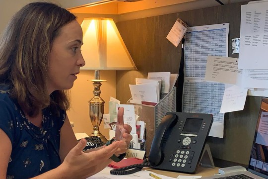 professor in office talking on Zoom call.