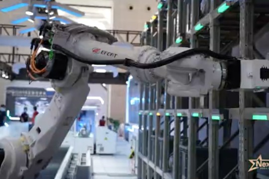 a robotic arm takes something off a shelf in a warehouse.