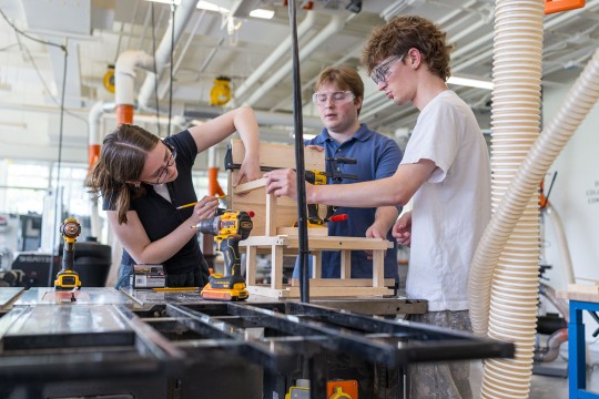 students work together in a woodworking shop