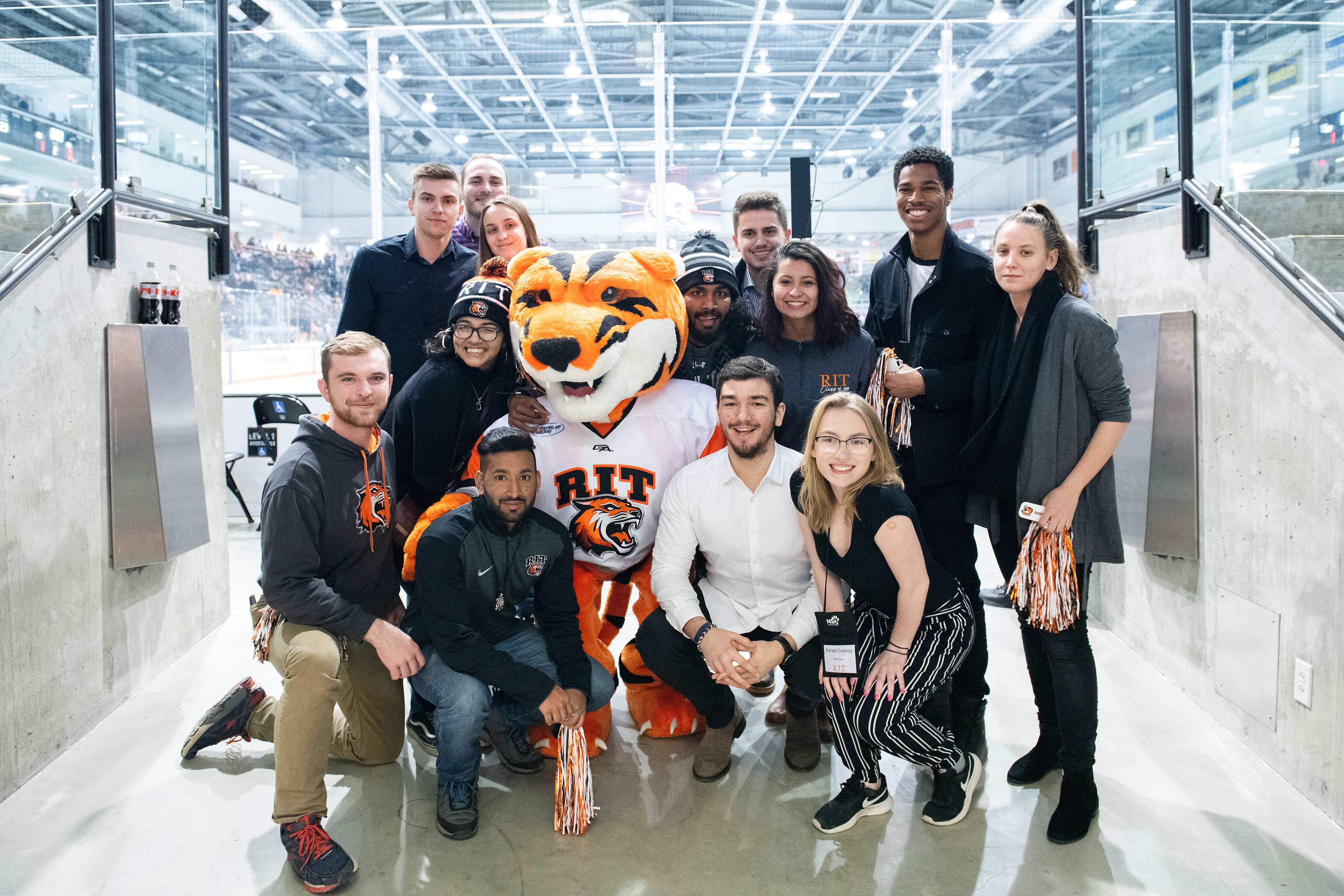 Visitors posing with RIT mascot Ritchie