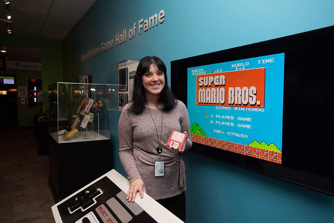 A woman standing infront of super mario bros video game
