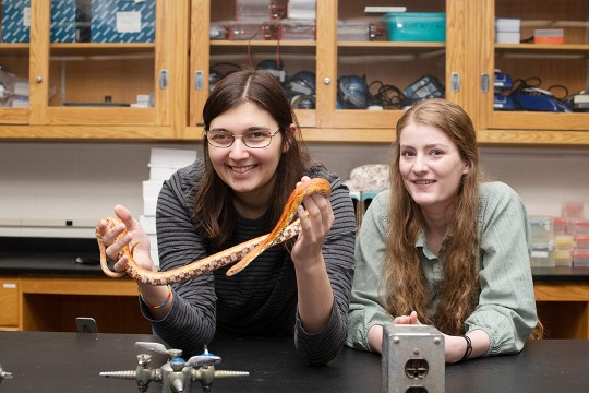 two girls student posing with snake prop