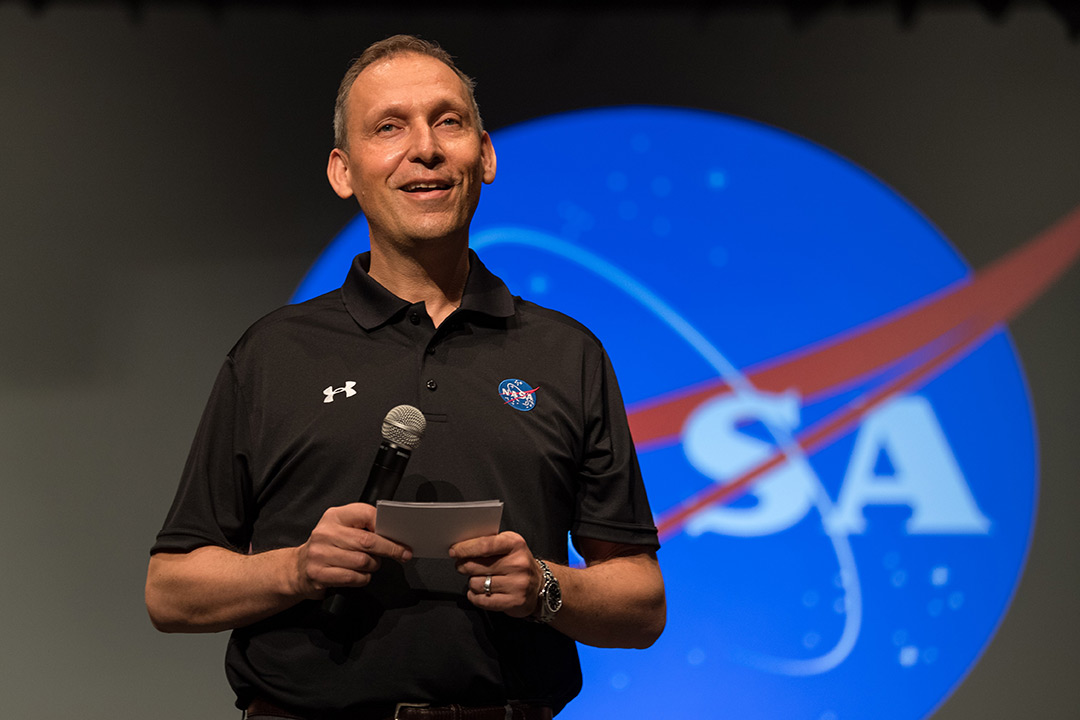A man standing in front of NASA logo