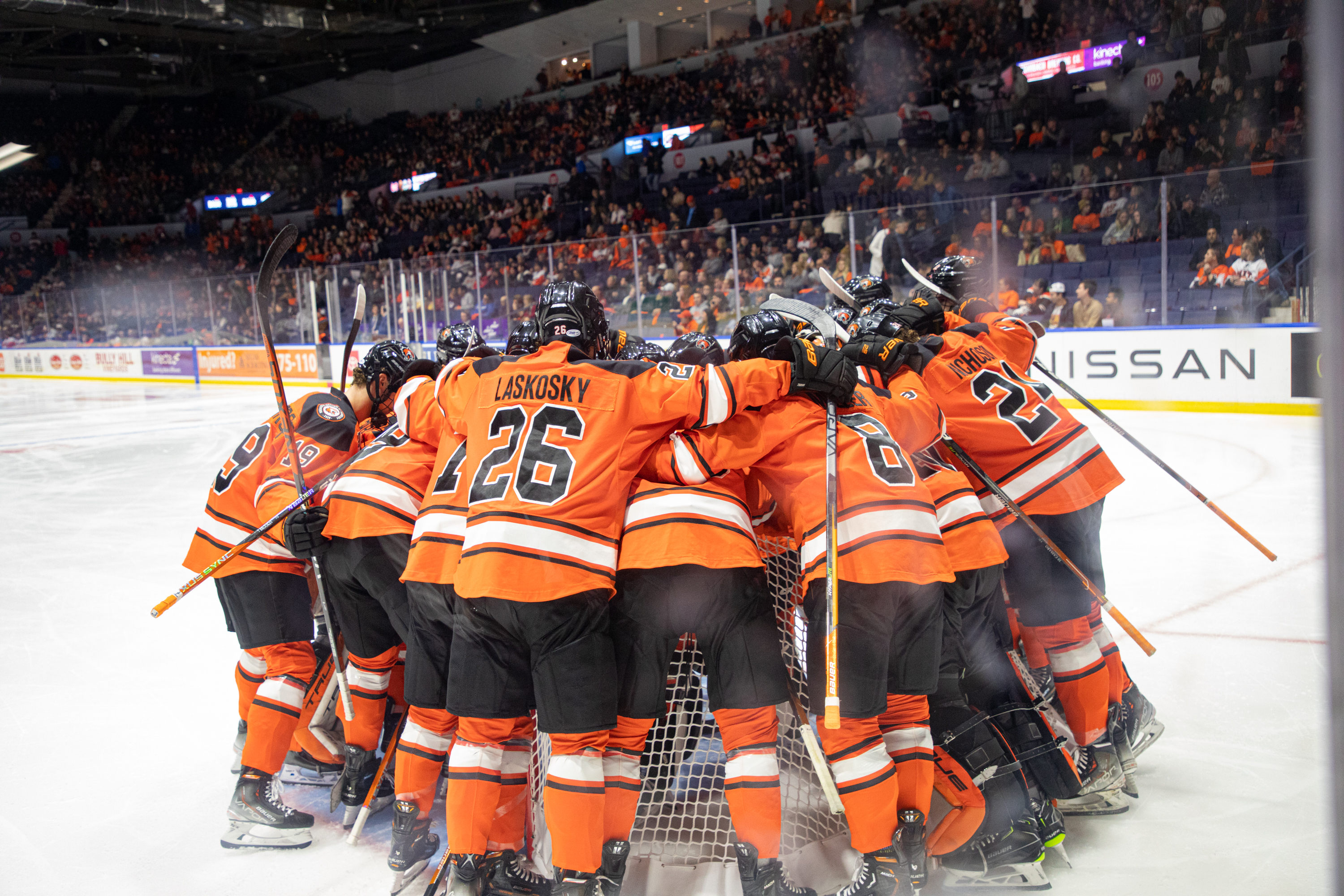 a huddle of RIT men's hockey players