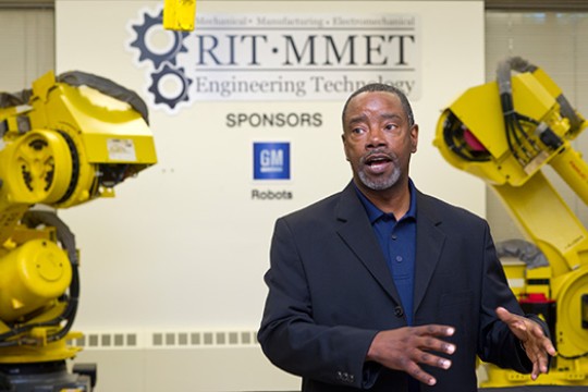 Person posing next to robots