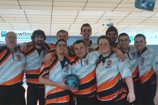People posing with bowling ball