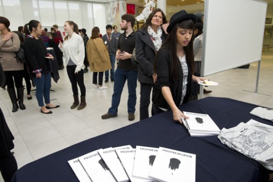 person picking up a magazine from a table at a reception.