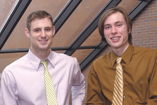 Two students standing in front of window