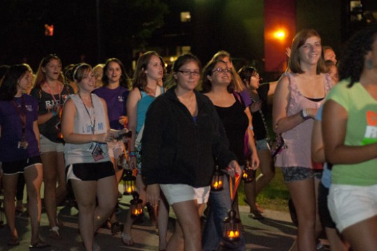 People walking down pathway at night